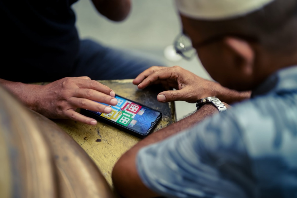 Close up of hands playing a mobile MOBA game on a smartphone