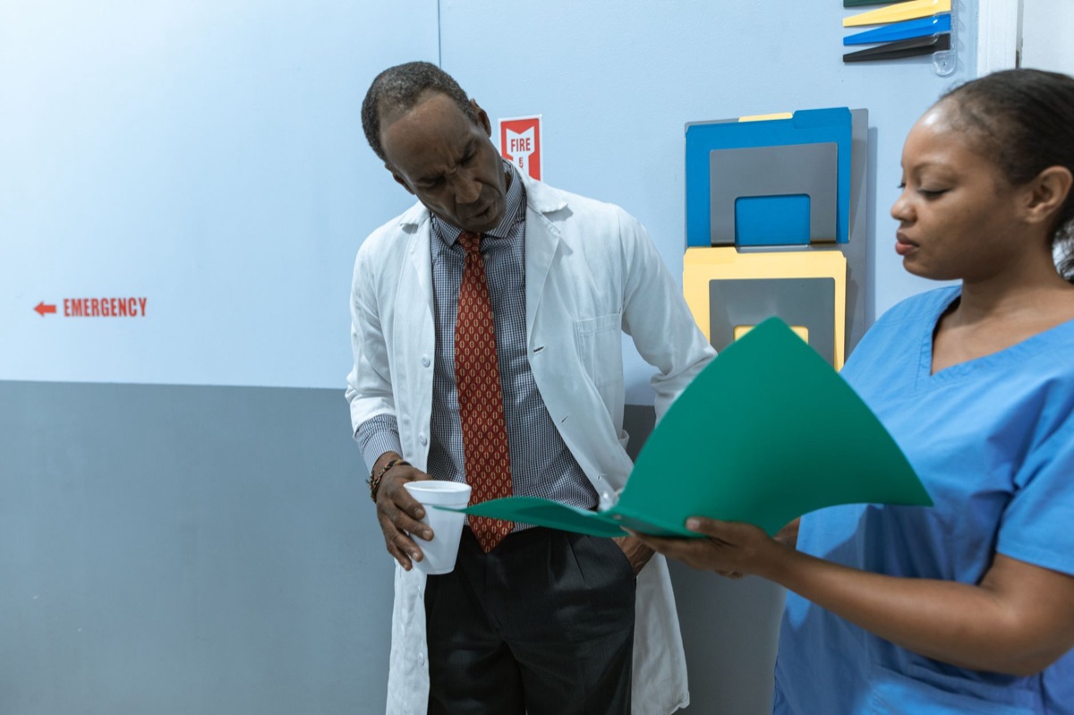 Filipino nurse holding medical chart in professional setting