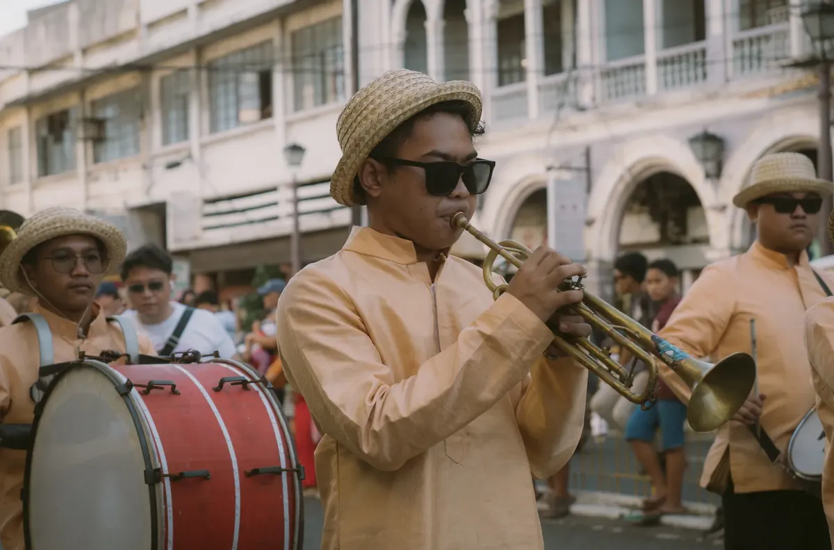 A vibrant marching band performance in Iloilo City, Philippines, showcasing traditional music and cultural attire.